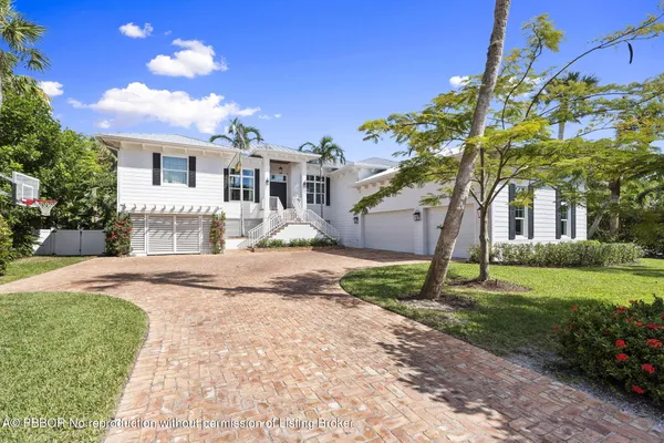 a front view of a house with a yard and potted plants