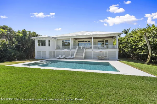 a view of an empty room with wooden floor and fan