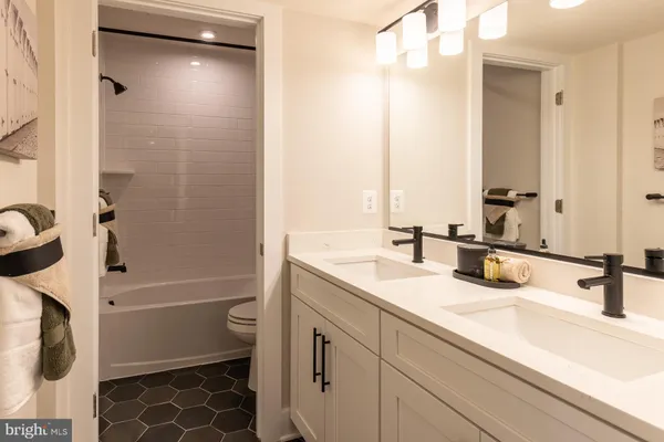 a bathroom with a tub sink and mirror