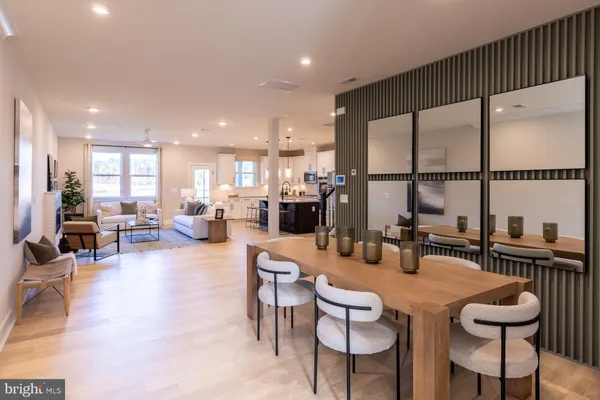 a kitchen with a dining table chairs and view of living room