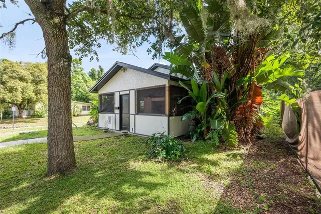 a white house that has a tree in front of a house