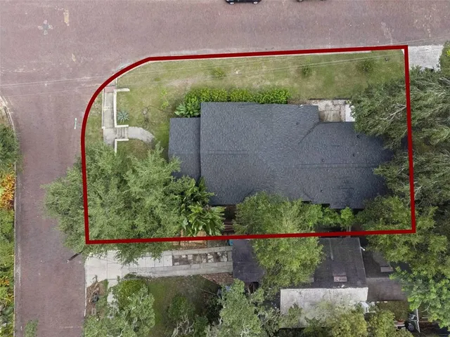 an aerial view of residential houses with outdoor space and trees