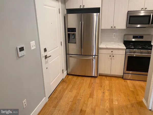 a kitchen with stainless steel appliances a refrigerator stove and microwave