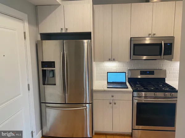 a kitchen with cabinets and stainless steel appliances