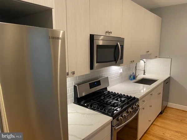 a kitchen with stainless steel appliances granite countertop a refrigerator and a stove top oven