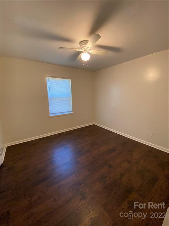 3708 Kelly Road Charlotte, NC 28216 - Photo 7 of 12 an empty room with wooden floor and windows