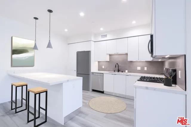 a kitchen with sink refrigerator and stove