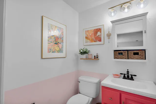 a bathroom with a toilet a sink and mirror