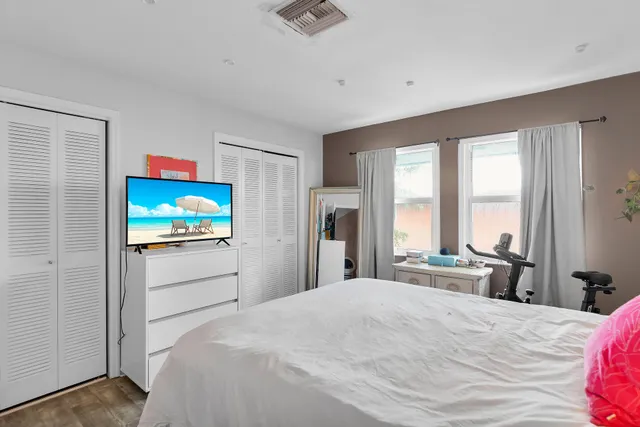 a bedroom with a bed and a flat screen tv