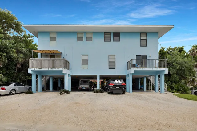 a front view of a house with a yard and parking space