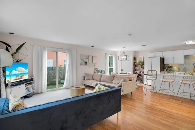 a living room with furniture a flat screen tv and wooden floor