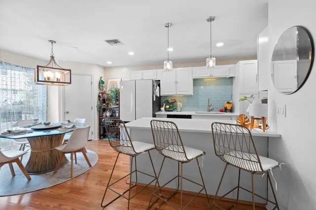 a view of kitchen with stainless steel appliances granite countertop dining table chairs and view of living room