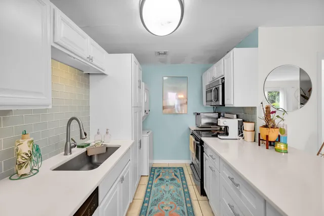 a kitchen with a sink a stove and cabinets
