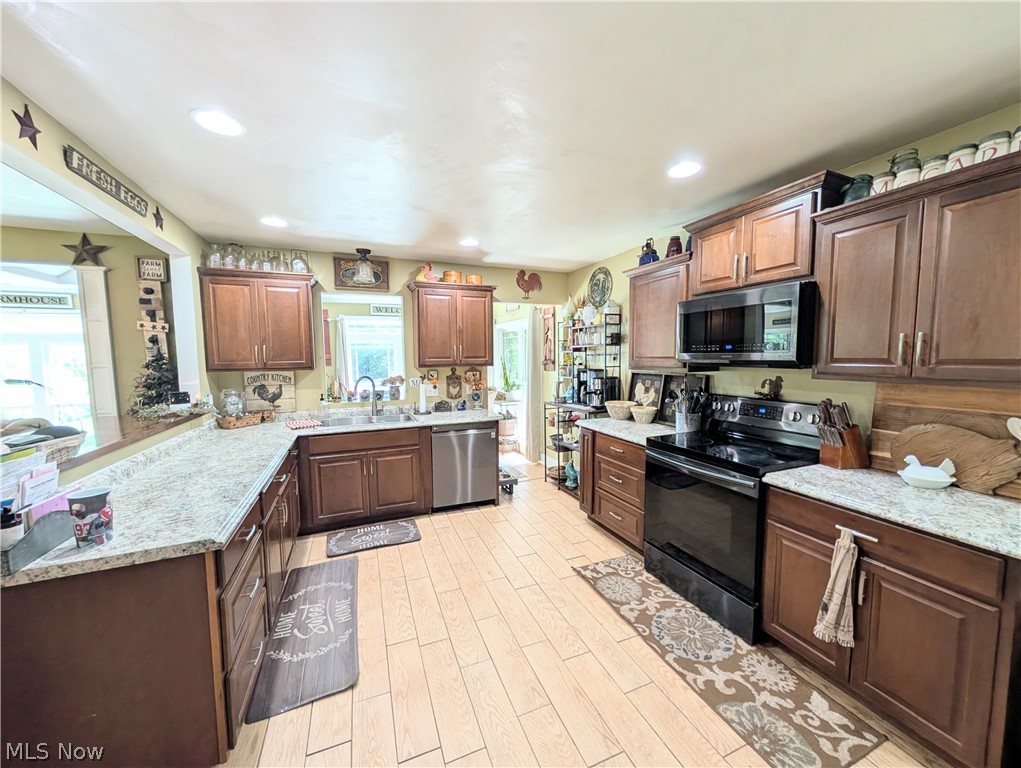 6700 McCaslin Road Nashport, OH 43830 - Photo 18 of 30 Spacious kitchen featuring extensive wood cabinetry, light-toned countertops, and light wood-finish flooring