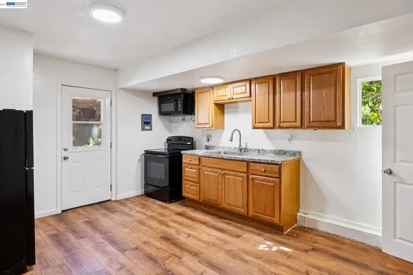 a kitchen with granite countertop a refrigerator sink and cabinets