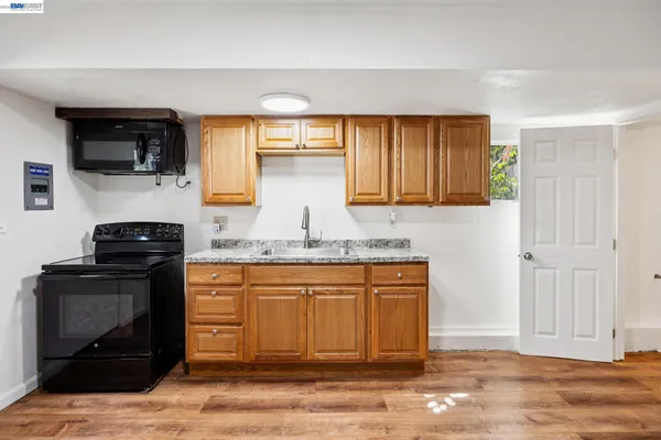 a kitchen with stainless steel appliances granite countertop a stove a sink and a microwave