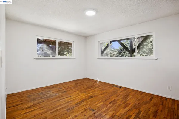 a view of empty room with wooden floor