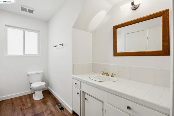 a bathroom with a sink a toilet and a mirror