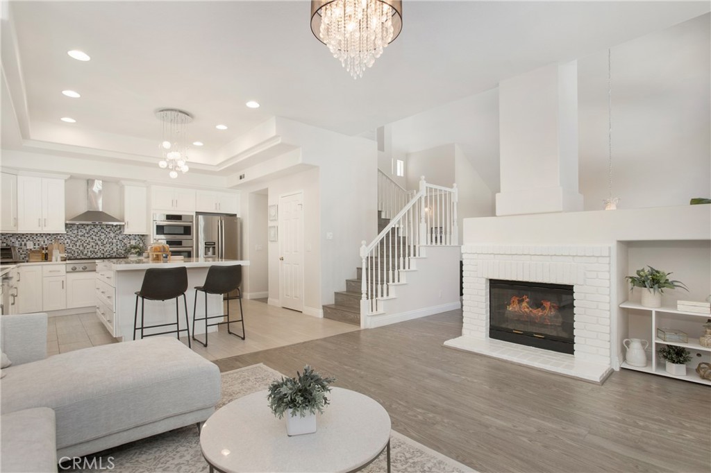 17 Calle Cabrillo Lake Forest, CA 92610 - Photo 11 of 44 a living room with furniture a fireplace and a chandelier