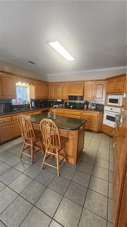 a kitchen with stainless steel appliances a stove a sink a dining table and chair