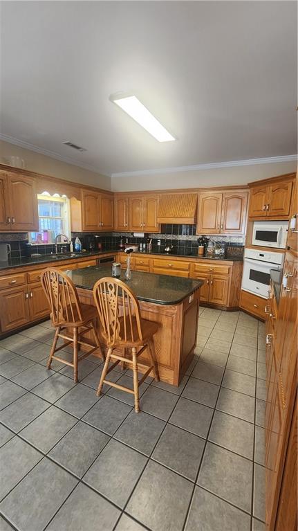 1 North Kenora Drive Southwest Rome, GA 30165 - Photo 8 of 24 a kitchen with stainless steel appliances a stove a sink a dining table and chair