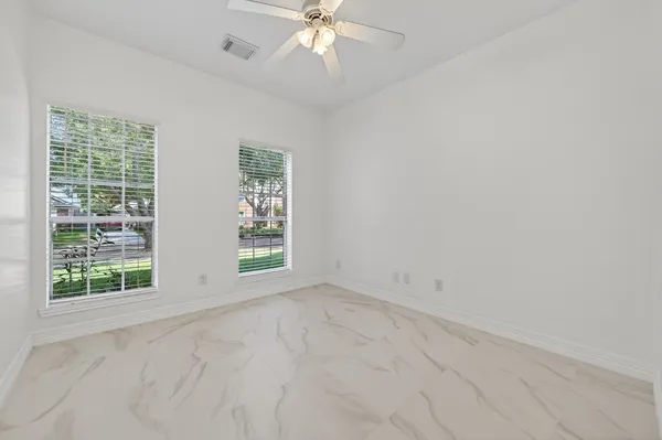 an empty room with a window and a fan