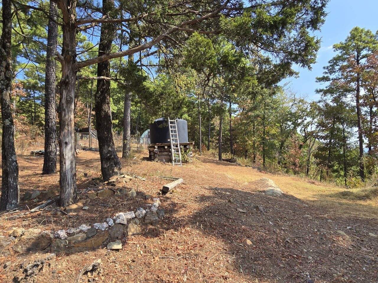 1097 Flagpole Road Clayton, OK 74536 - Photo 24 of 32 Mature trees throughout the property, elevated water tank, and natural rock retaining wall