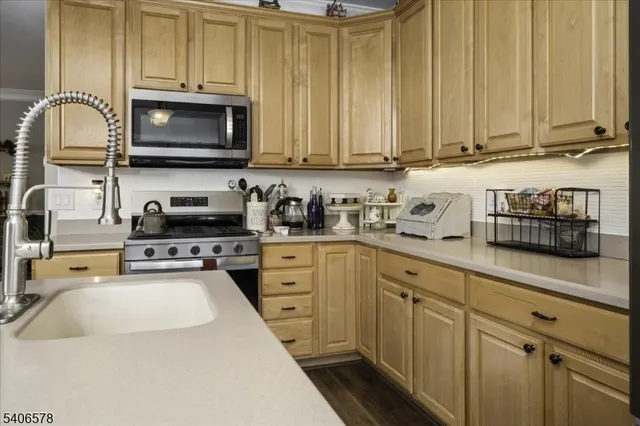 a kitchen with stainless steel appliances granite countertop a sink a stove and cabinets