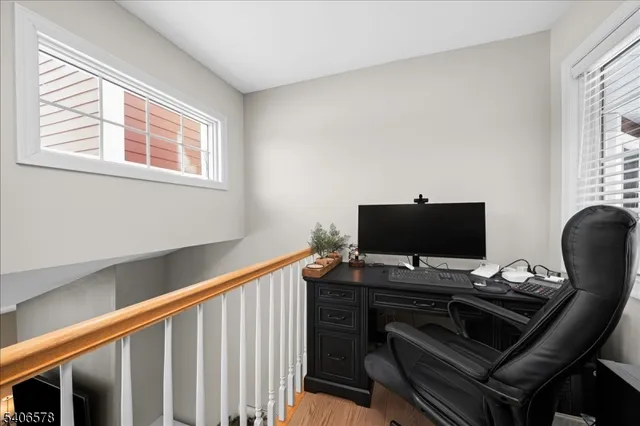 a view of a workspace with furniture and a window