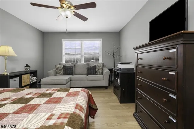 a bedroom with a bed and a flat tv screen on dresser