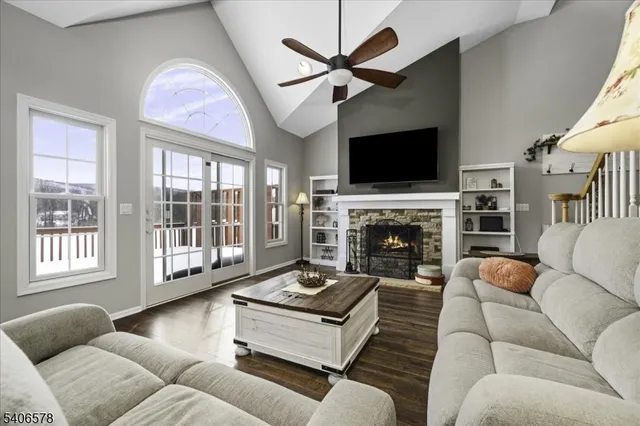 a living room with furniture a flat screen tv and a fireplace