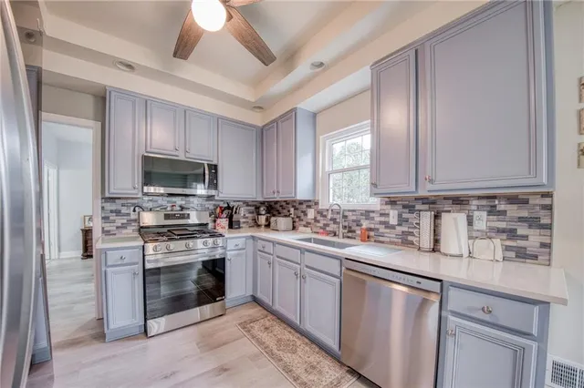 a kitchen with stainless steel appliances granite countertop a stove sink and cabinets