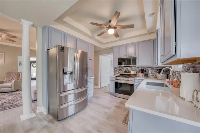 a kitchen with stainless steel appliances a refrigerator a stove top oven a sink and dishwasher