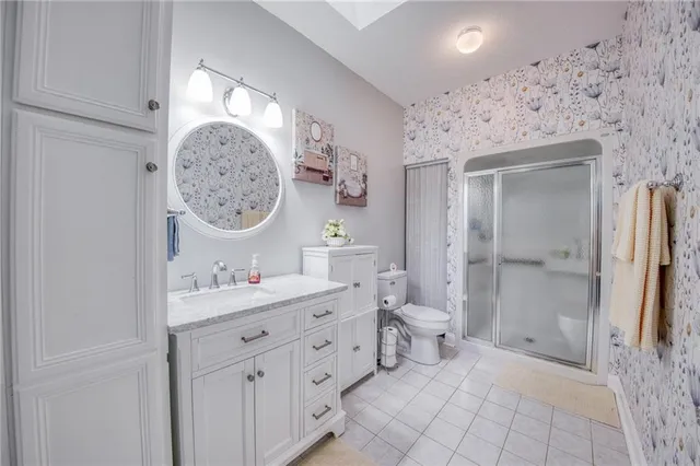 a spacious bathroom with a double vanity sink toilet and shower