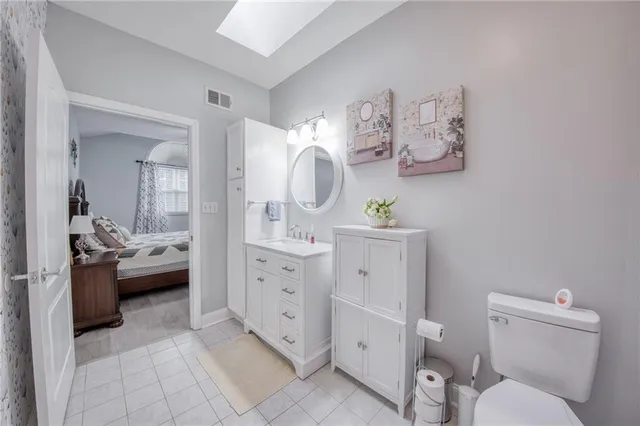 a spacious bathroom with a toilet sink and mirror