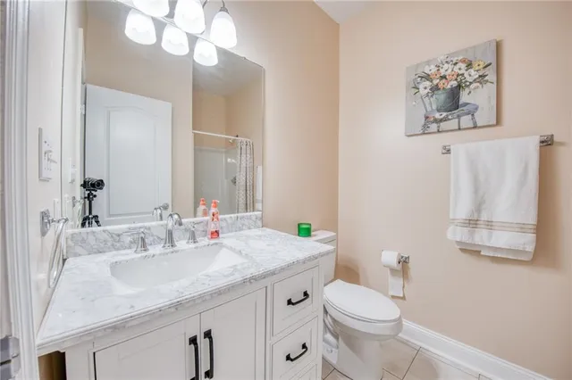 a bathroom with a granite countertop toilet sink and mirror