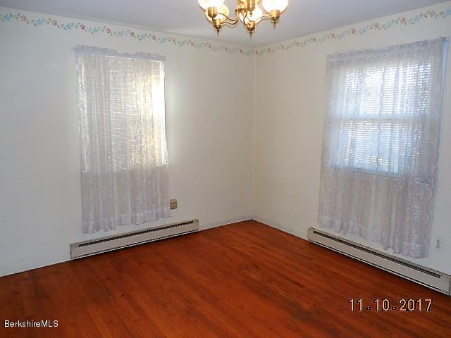 184 Washington Mountain Road Lee, MA 01238 - Photo 11 of 26 an empty room with wooden floor cabinet and windows