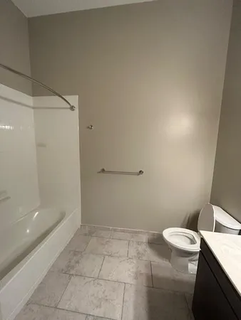 a bathroom with a granite countertop toilet and a shower
