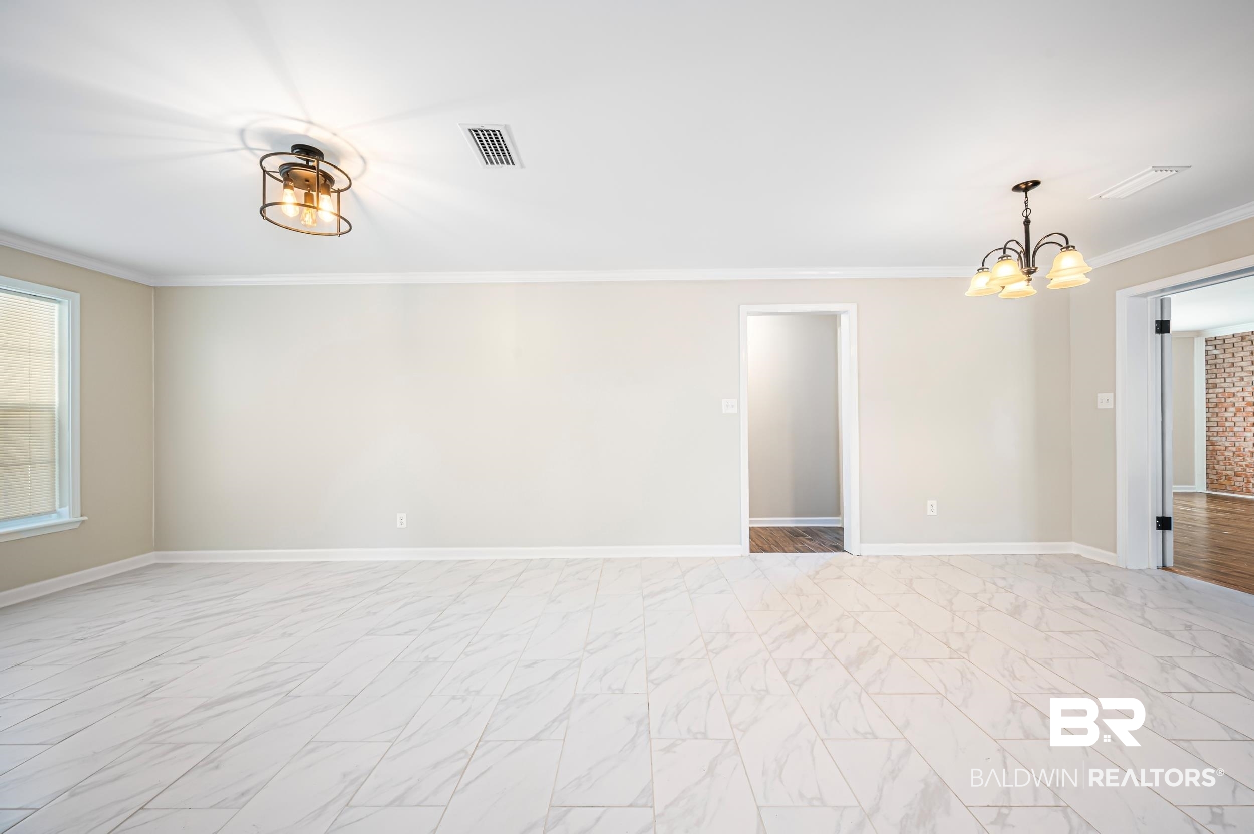 1605 Collier Avenue Bay Minette, AL 36507 - Photo 19 of 36 Empty room with a chandelier, ornamental molding, and light marble finish flooring
