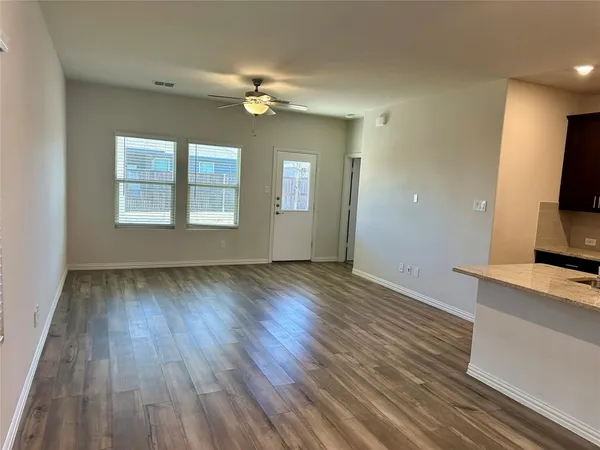 an empty room with windows and fan
