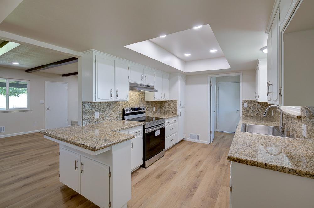351 North Peach Avenue Clovis, CA 93612 - Photo 11 of 34 a kitchen with granite countertop a sink stove and refrigerator