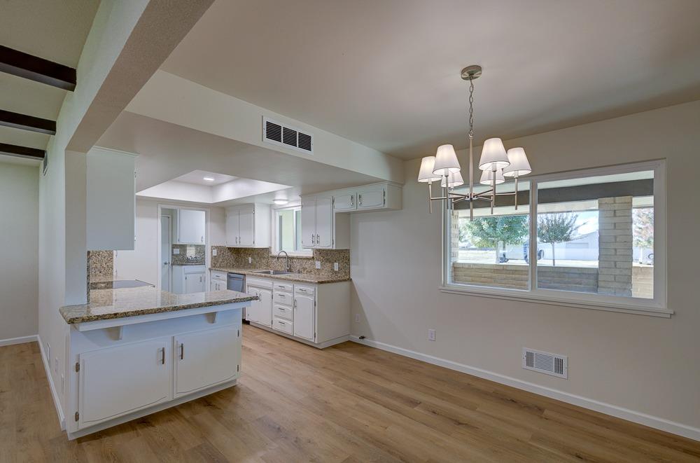 351 North Peach Avenue Clovis, CA 93612 - Photo 9 of 34 a kitchen with stainless steel appliances granite countertop a stove a sink dishwasher a refrigerator and a wooden floor