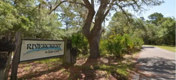 a sign that is sitting in front of a tree