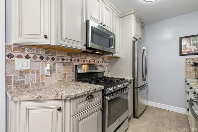 a kitchen with stainless steel appliances granite countertop a stove and a refrigerator