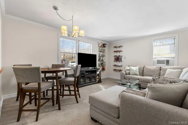 a living room with furniture a flat screen tv and a chandelier