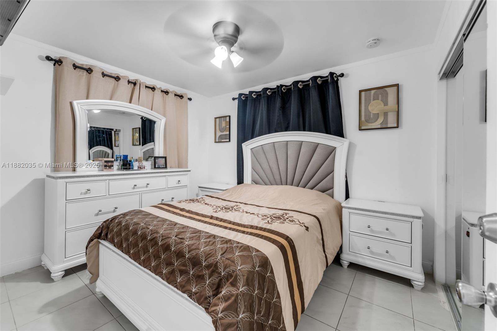 12750 Southwest 197th Avenue Miami, FL 33196 - Photo 12 of 60 a bedroom with a large bed and a chandelier