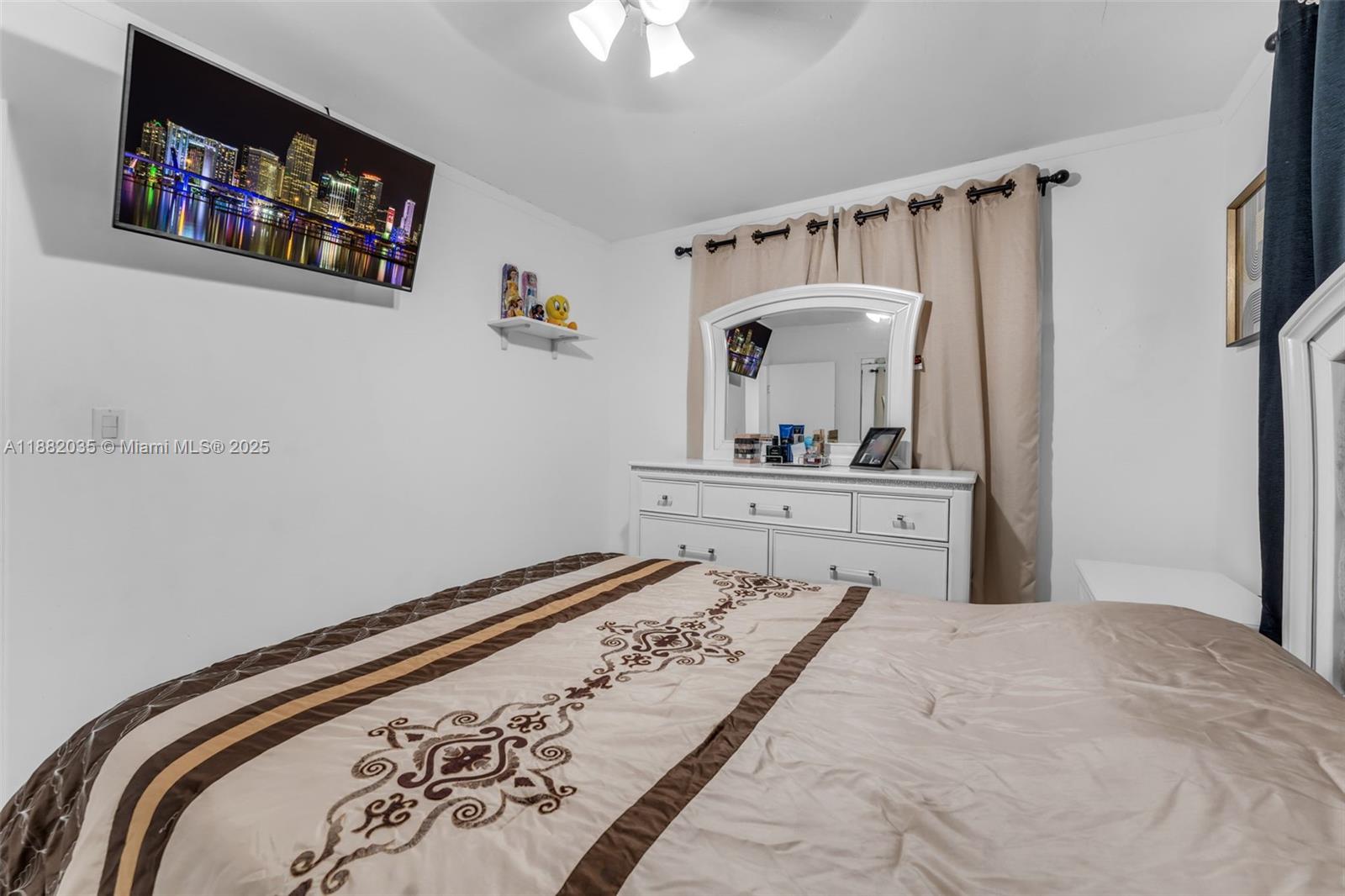 12750 Southwest 197th Avenue Miami, FL 33196 - Photo 13 of 60 a bedroom with a bed and a chandelier