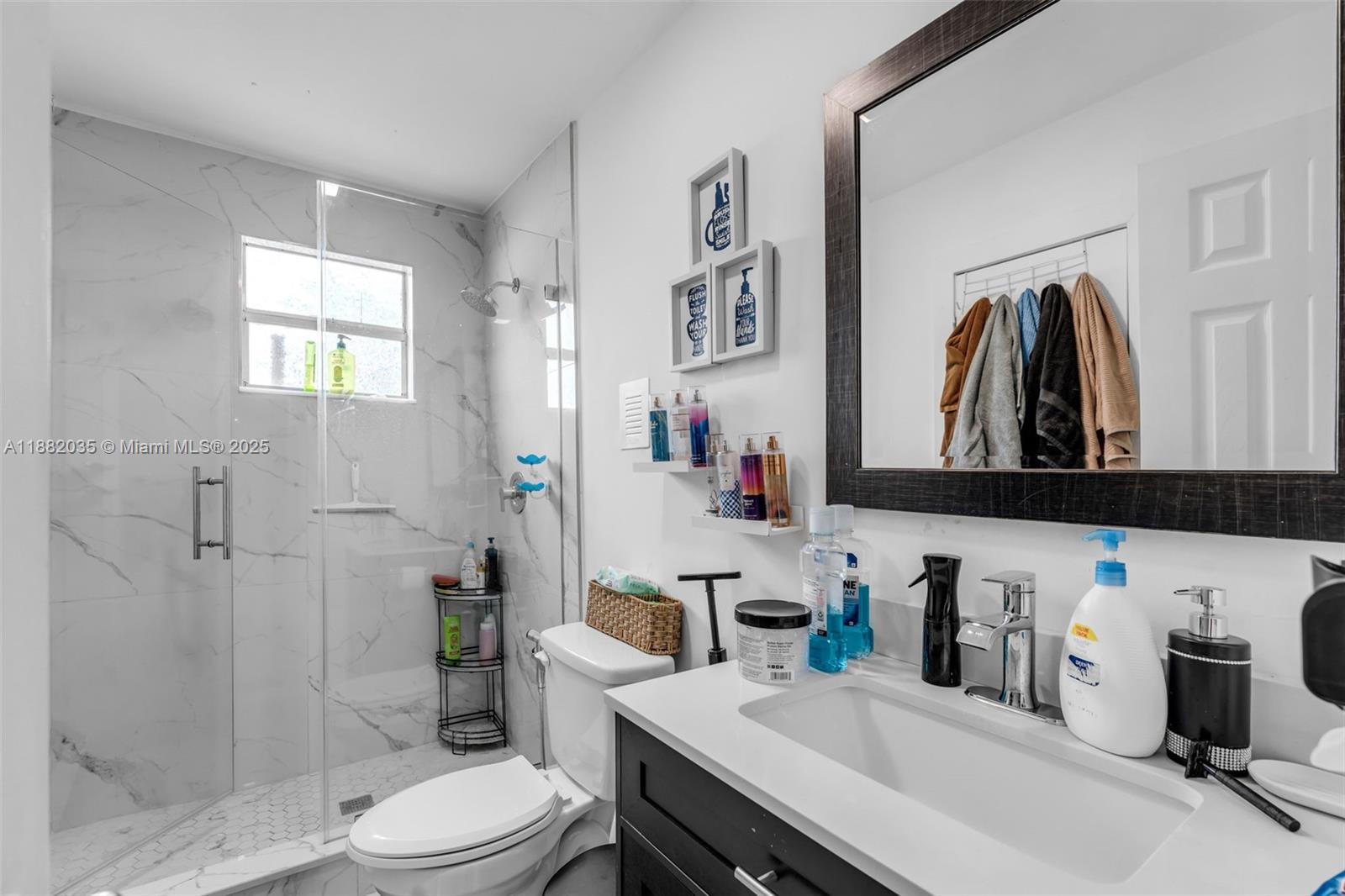 12750 Southwest 197th Avenue Miami, FL 33196 - Photo 29 of 60 a bathroom with a sink a toilet and shower