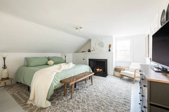 a spacious bedroom with a bed and a flat screen tv