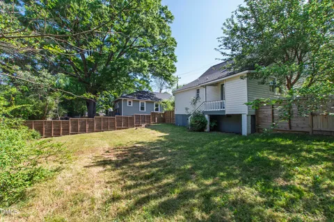 a view of a house with a backyard and a tree